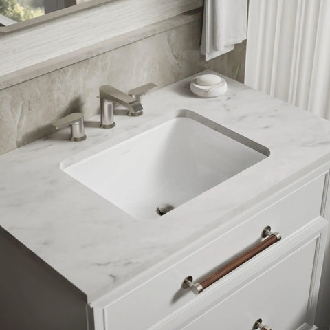 Roomy Rectangular Undermount Bathroom Sink With Overflow Drain Crafted From Hella Durable Vitreous China For An Easy Vanity Setup Bringing Straight Up White Finish And Really Smooth Daily Performance on a marble countertop.