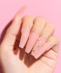 Hand with long pink nails using HEMA Free Rubber Base Gel Kit For Nails Soak Off UV LED Clear Sheer Gel Polish 4 In 1 Kit 45