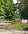 Heavy Duty Aluminum No Dumping Signs Two Pack Shut Down Illegal Dumpers Keep Yard Shipshape UV Blocked sign near a dirt path.
