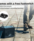 Person using 15W Portable Guitar Amp With 9 Preamp Models, Looper, Drum Machine, and footswitch on paved ground in sunlight