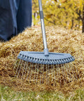 Adjustable 17 To 63 Inch Thatch Rake With 24 Steel Tines detaching thatch on a lawn, featuring ergonomic handle and lightweight design.