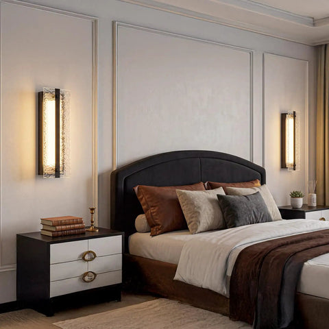 ElilyGiA 16 Inch Modern LED Wall Sconce Vanity Light, Black illuminating a stylish bedroom with decorative pillows and bedside decor.