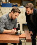 Two men using a Sturdy Rotary Tool Stand For A Stable Drill Press Makeover on a wooden table in a workshop setting.