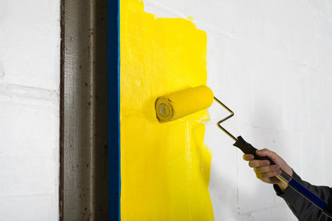 Heavy-Duty 9 Inch Microfiber Woven Paint Roller Covers With A Snug 3/4 Inch Nap painting a yellow wall indoors.