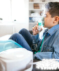 Boy using a nebulizer with bulk pack of 100 round white air filter sponges for compressor systems replacement filters visible