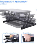 32 Inch Height Adjustable Standing Desk Converter With Slide Out Keyboard Tray and Dual Monitor Riser showing height adjustment mechanics.