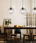 Globe Pendant Lights Set of 3 Hand Blown Glass With Clear Seeded Bubbles over dining table, modern rustic kitchen lighting.