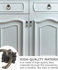Close-up of 6pc Antique Bronze Cabinet Pull Handles Set on white cupboard, vintage knobs for retro style furniture.