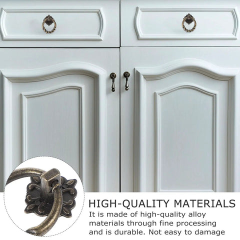 Close-up of 6pc Antique Bronze Cabinet Pull Handles Set on white cupboard, vintage knobs for retro style furniture.