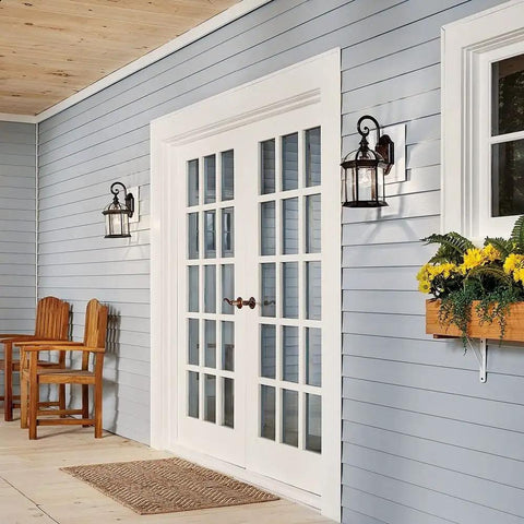 Durable Outdoor Wall Light In Black Finish With Clear Beveled Glass on porch next to white doors.