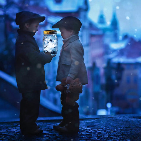 Two children holding a lit jar in snow, showcasing 12 Pack Solar Mason Jar Fairy Lights With 30 Warm White LEDs, no jars included.