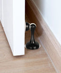 Heavy Duty Magnetic Door Stop Set, 2 Pack, Stainless Steel Black Finish, No Drill Adhesive Door Stops For Wall Or Floor Mount, Strong Tape, Keeps Doors Open, Protects Walls From Slams installed on wall behind door