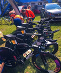 Line of black BMC bicycles displayed outdoors at an event.