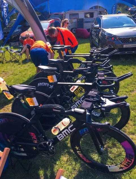 Line of black BMC bicycles displayed outdoors at an event.