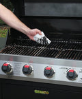 Person cleaning barbecue grill with Heavy Duty Surface And Hand Wipes 2 Pack 60 Count Pre Moistened Shop Wipes Tackle Paint Oil Grease Adhesives Mud And Dirt From Surfaces Tools And Gear.