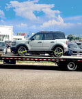 SUV secured on trailer with 4 Pack 2 Inch By 8 Foot Car Tie Down Ratchet Straps With Chain Anchors, 3335 LBS WLL, High Viz Green Tire Straps