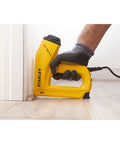 Heavy Duty Electric Staple And Brad Nail Gun With Dual Hi Lo Trigger For No Sweat Woodworking One Half Nine Sixteenths And Five Eighth Brads Eight Foot Cord Real Mule Power in use, stapling baseboard.