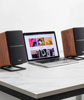 R1280DBs Active Bluetooth Bookshelf Speakers With Optical Input And Sub Out 2.0 Studio Monitor Sound 42W RMS Wood Grain Finish on desk