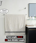 Heavy-Duty 33 Inch Stainless Steel Towel Bar for Bathrooms With 304 Brushed Finish holding a towel, wall-mounted near a sink.