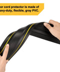 Hands bending Heavy Duty Floor Cable Cover Protector made of gray PVC with three channels for safe cord protection.