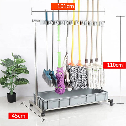 Floor Mounted Broom And Mop Holder Rack With Thick Rubber Clips Movable Cabinet Organizer For Garage Workshop And Kitchen Keeps Mop Drain Rack Handy And Easy Access Tool Corner Storage. Metal rack with wheels holding various cleaning tools.