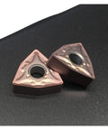 Two triangular carbide turning inserts with center mounting hole, pink coating; WNMG080408 MA15TF for CNC lathe.