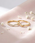 Stackable Pinky Ring For Women Stainless Steel Solitaire Band In Gold on pink background with flowers, non-tarnish, comfortable fit