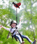 Child using Backyard Zip Line Kit For Kids And Adults, 120 Foot Outdoor Zipline With Swing Seat, Spring Brake And Safety Harness