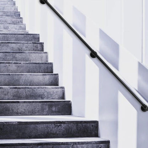 Heavy Duty 7 Ft Metal Industrial Pipe Stair Handrail In Glossy Black Finish mounted on indoor concrete stairs.
