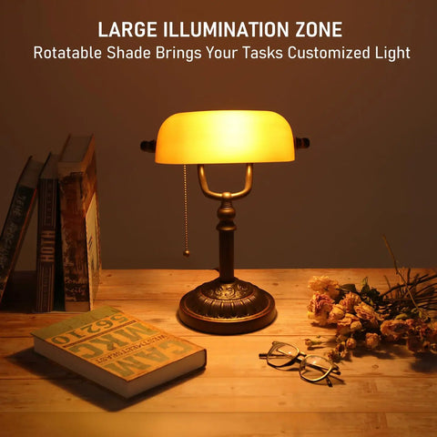 Amber Glass Bankers Desk Lamp With Retro Weighted Base And Old School Vibe on wooden desk with books and flowers
