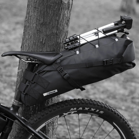 Black waterproof bike saddle bag with expandable 10L and 13L capacity, attached under seat on bicycle for mountain road biking.