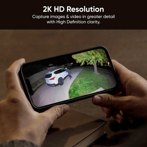 Hands holding smartphone showing footage from Outdoor Floodlight Security Camera 2K HD With Color Night Vision, 2800-Lumen LEDs.