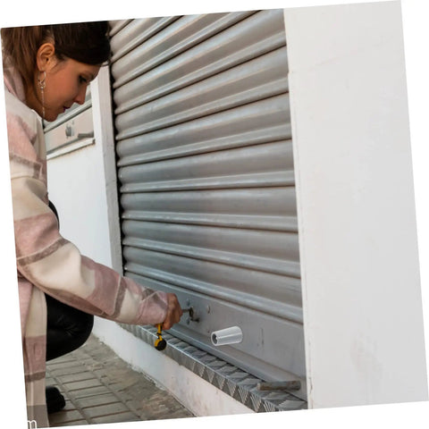 Person using Badass Hurricane Shutter Hardware Plus Window Shutter Stopper Kit to adjust a roller shutter.