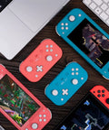Pocket Sized Lite 2 Bluetooth Controller with motion controls and linear vibration motors in pink and blue next to gaming devices.