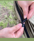 Hands zipping a section of the Camping Hammock Tent With Net And Portable Sleeping Cot For Backpacking And Hiking Travel 3 In 1 All In One Outdoor Gear With Rain Fly Heavy Duty 440 Lbs Capacity