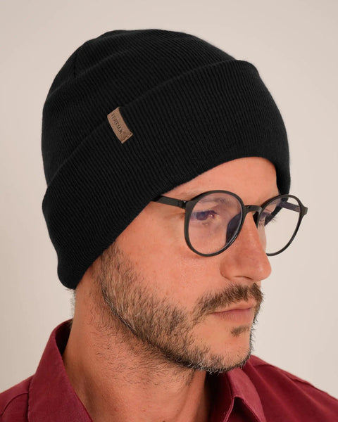 Man wearing Unisex Cuffed Beanie Thick Double Knit Winter Skull Cap Black Cozy Warm For Skiing Running And Daily Cold Weather Protection