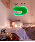 Totally Lit Dinosaur Head Neon Sign For Kids Bedroom Decor USB Or Battery Powered Neon Light Wall Art For Home Office Parties Halloween Valentines Day Wedding Gifts hanging above a cozy bed setup.