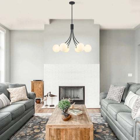 Modern living room with minimalist pendant light above wooden coffee table, featuring a cozy seating area and large windows.