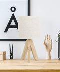 Set Of 2 Cute Wooden Tripod Bedside Lamps With Linen Fabric Shade on wooden desk with decorative items and artwork