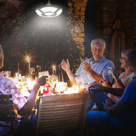Outdoor dining scene with Two Pack Solar Shed Light With 136 LEDs Brighter Solar Light illuminating table
