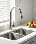 Rock Solid Kitchen Faucet With Smooth Pull Down Sprayer In Clean Brushed Nickel Finish above double sink with fresh fruit.