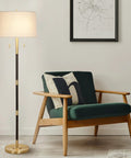 Transitional 2 Light Floor Lamp With Dual Pull Chains In Black And Antique Brass Finish, 56.5 In Tall beside a green armchair