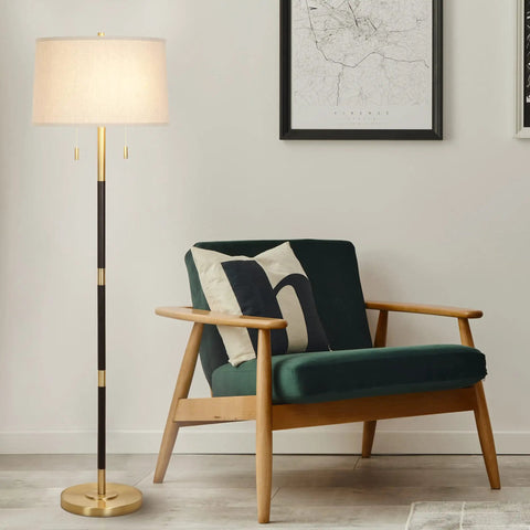 Transitional 2 Light Floor Lamp With Dual Pull Chains In Black And Antique Brass Finish, 56.5 In Tall beside a green armchair