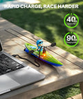 Dual RC Kayaks For Kids 6-12 With Magnetic Dolphin Nose And Three Balls charging beside a laptop on a wooden table