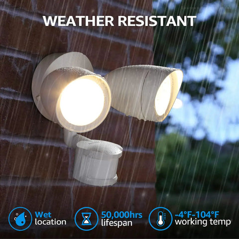 Motion Sensor LED Flood Light With Dual Adjustable Heads For Outdoor Security mounted on brick in rain, lit and weather resistant.