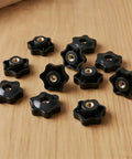 Top Shelf Set 20 Piece Slick Star Knob T Track Bolts With Quarter Inch Female Thread Hexagon Head For Woodworking Jigs Lawnmowers And Patio Umbrellas Easy Grip Solid Clamp Hardware In Matte Black, close-up view on wood.