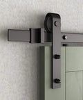 Close-up of installed J-shape sliding barn door hanger on track, black solid steel with POM wheels for smooth door movement.