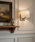 Edwarmlux Indoor Wall Sconces, Brushed Nickel, 1 Pack, E26 Bulbs Excluded, displayed beside a wooden shelf and painting.
