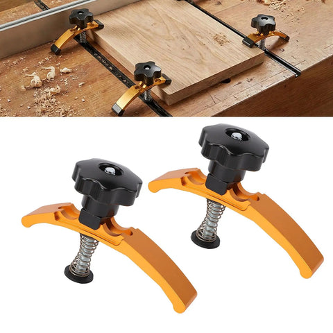 4 Piece Heavy Duty Aluminum T Slot Hold Down Clamps For Woodworking CNC Router And Milling Machine with rubber coated ends on a wooden surface.
