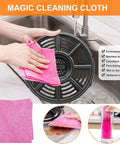 Magic Cleaning Cloth being used to wipe a black crisper tray in a sink, highlighting the durable material and easy cleaning.